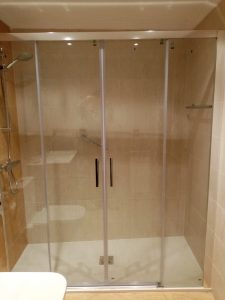 Cambiar bañera por ducha en Bilbao con decorado beige en las tres paredes de la ducha y plato de ducha de mármol blanco