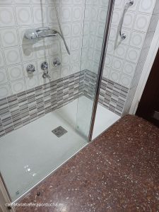 Cambio de bañera en Laguardia (Álava). Plato de ducha de mármol con azulejo en moasico azul y mampara frontal con cristal fijo de 1 metro y abatible de 25 cm