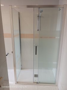 En Logroño cambio de bañera por ducha con plato de mármol, mampara frontal + lateral fijo y azulejos en color blanco con detalles con cenefa rosa
