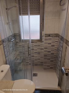Bañera por ducha en Bibao (Santutxu). Plato de mármol blanco, azulejo en color azul y mampara trio 1 fijo + 2 correderas.