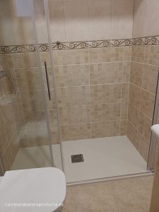 Cambio de bañera en Lodos. Plato de ducha de mármol técnico en color blanco. Mampara trio 1 fijo + 2 correderas con un máximo de apertura para un mejor acceso a la ducha. Azulejo en color beige mosaico harta 1 metro de altura. Elevación de las tomas del grifo a 1 metro de altura.