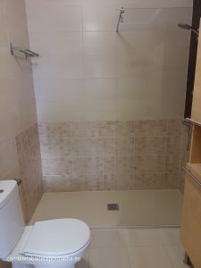 Baño con cambio de bañera, plato en color beige y mampara con 1 vidrio fijo Cambio de ducha en Haro. Plato de ducha de mármol técnico en color crema combinando el azulejo tipo mosaico en beige. Mampara con un cristal fijo de 90 cm transparente. Subir las tomas del grifo a una altura de 90 cm.