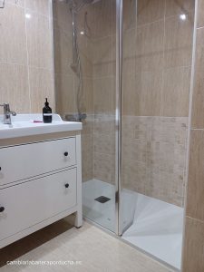 La imagen muestra un baño moderno en Logroño, con una ducha de vidrio instalada, reemplazando la antigua bañera. Los azulejos beige y un lavabo blanco complementan la estética limpia y contemporánea.