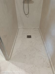 "Reforma de baño en Lardero: Nuevo plato de ducha de mármol técnico, instalación a ras de suelo y desagüe lineal.