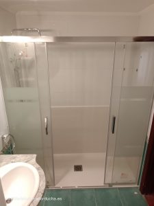Cambio de bañera por ducha sin obra en Zarratón: Plato de ducha de mármol, mampara de vidrio con 2 paneles fijos y 2 correderas, revestimiento de mármol en las paredes, grifo monomando y set de ducha.