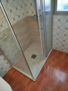 Cambio de bañera por plato de ducha en Huércanos (La Rioja). Reforma de baño con plato de ducha efecto mármol, mampara de vidrio y azulejos modernos en paredes y suelo.
